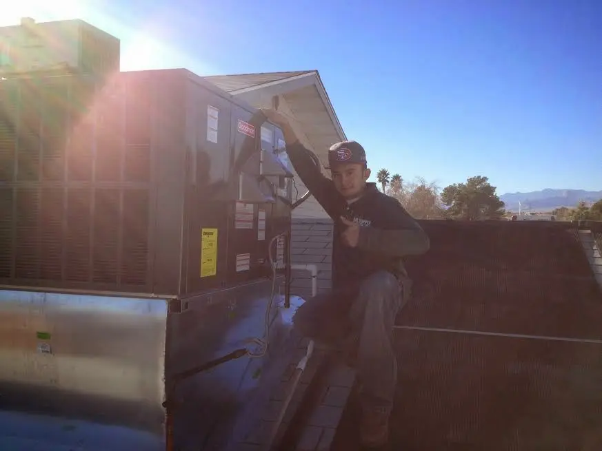 HVAC technician performing Air Duct Cleaning on a rooftop unit in Diamondhead